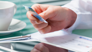 Person using a credit card for paperless payments on their tablet device