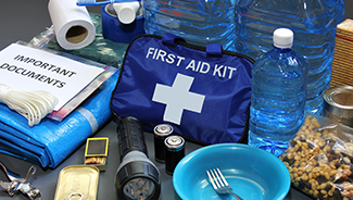 Emergency supplies including water, food, flashlights, batteries, and a first aid kit